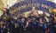 A group of men celebrate with the World Cup trophy amidst a shower of confetti